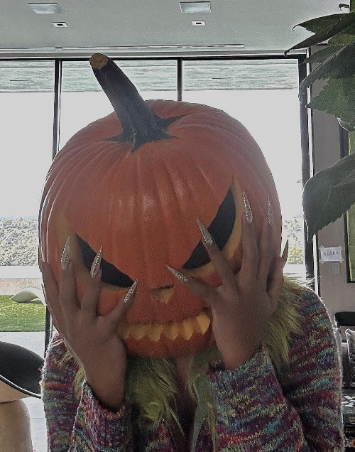 Megan Thee Stallion is having a hot girl halloween with her glittery nails and pumpkin theme.