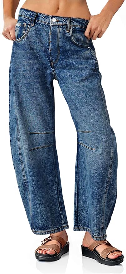 Wide-leg barrel-fit jeans in medium blue wash, shown from the front on a model. Features a mid-rise waist, curved seam detailing at the knees, contrast stitching, and a relaxed tapered silhouette. Worn with brown sandals.